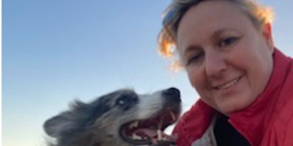 A person smiling beside a happy dog.