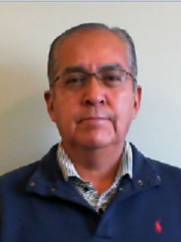 Portrait of a middle-aged man wearing glasses and a blue sweater.