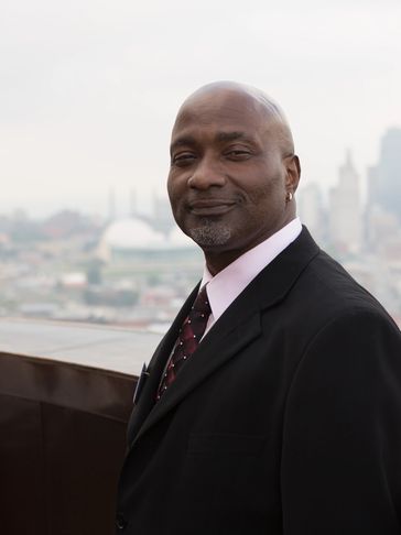 Man in suit with cityscape background.