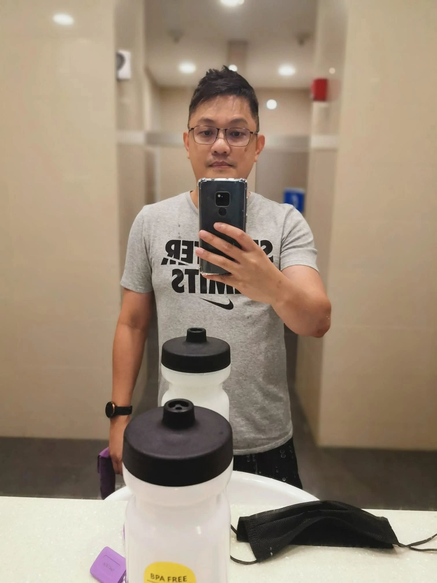 Man taking a mirror selfie in a bathroom.