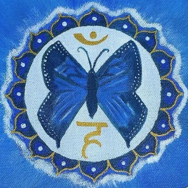 Blue butterfly with a white circular background and golden symbols, surrounded by blue petals.