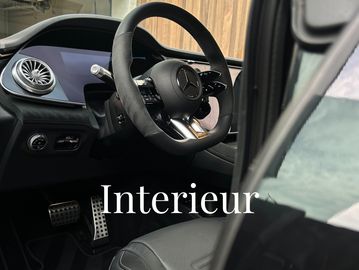 Luxurious Mercedes-Benz car interior with advanced controls and leather seats.