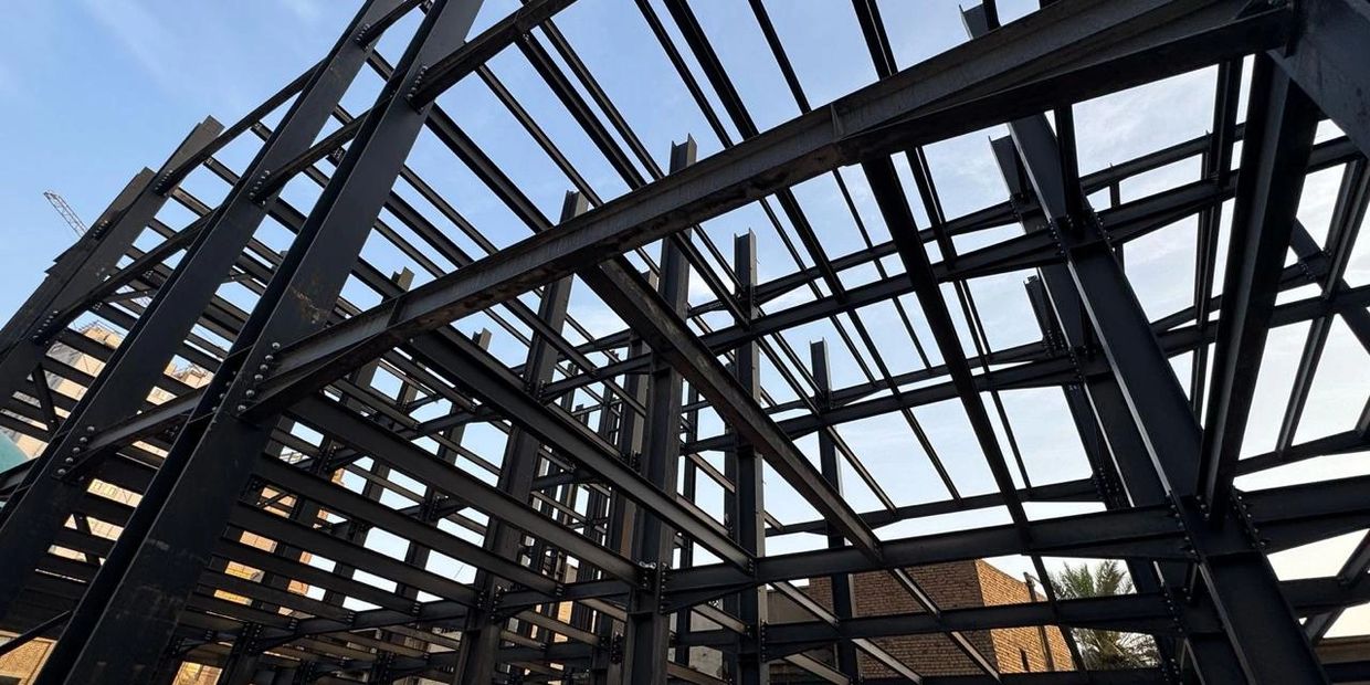 Steel framework of a building under construction against a clear sky.