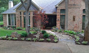 Brick house with landscaped garden and stone pathway.