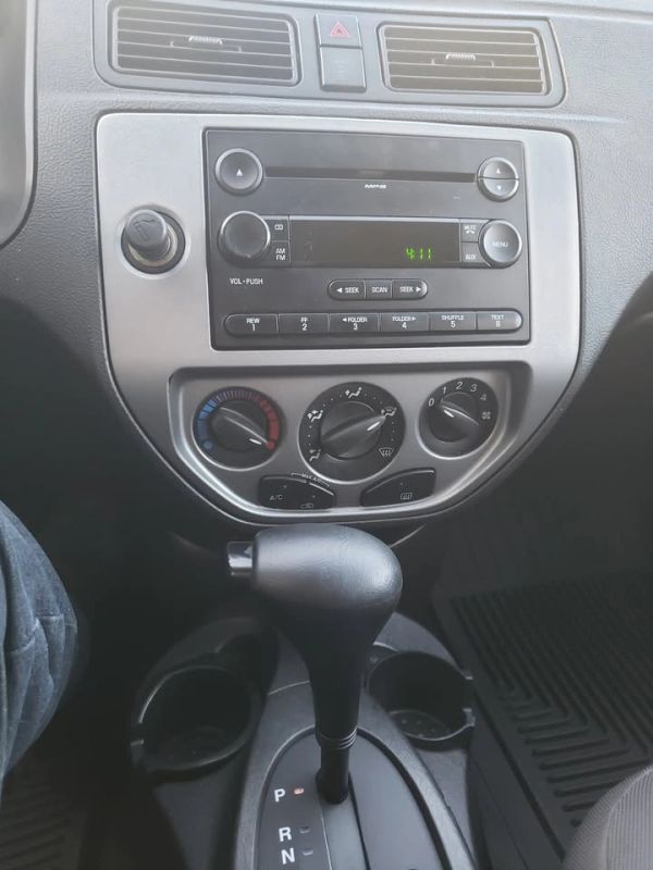 Car dashboard with radio and gear shift.