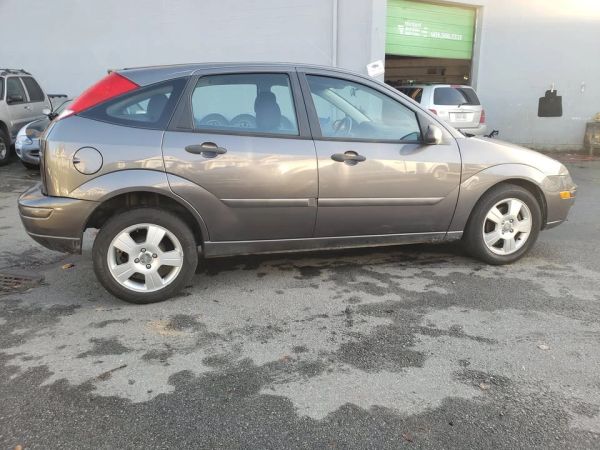 Side view of a hatchback car parked outside.