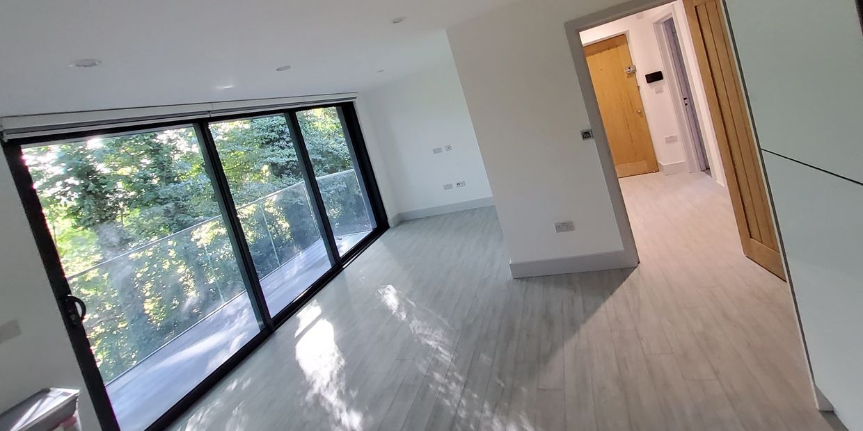 open space living room with sliding aluminium door, colour changing LED spotlights and @ProTek floor