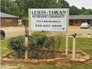 Sign for Lewis-Toran Retirement Community with contact details.