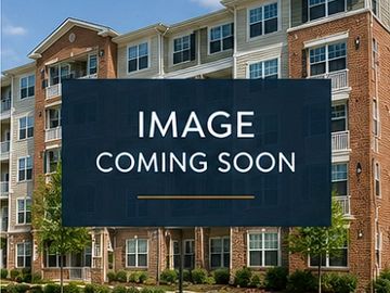 A multi-story residential apartment building with brick and siding exterior.