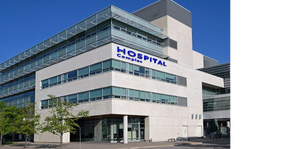 Modern hospital complex building under clear blue sky.