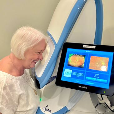 Elderly woman smiling during eye scan.