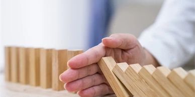 Image of Man knocking down wood dominos