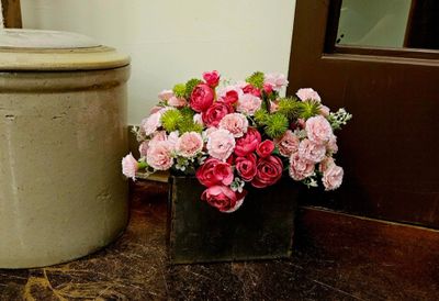 A vibrant bouquet of pink and red flowers in a black vase.