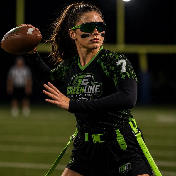 Female flag football player in action, wearing Greenline Elite Athletics gear.