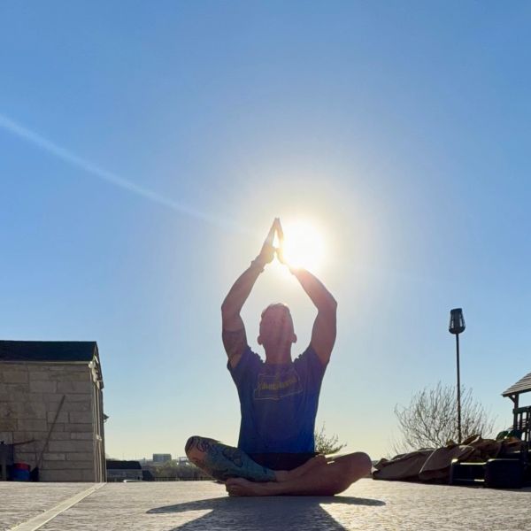 Person practicing yoga outdoors at sunrise or sunset.
