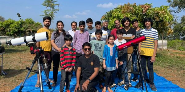 Guests at Namooru Ecostay enjoying a star-gazing event under a clear night sky.