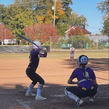 Softball batter preparing to swing while catcher and pitcher are ready.
