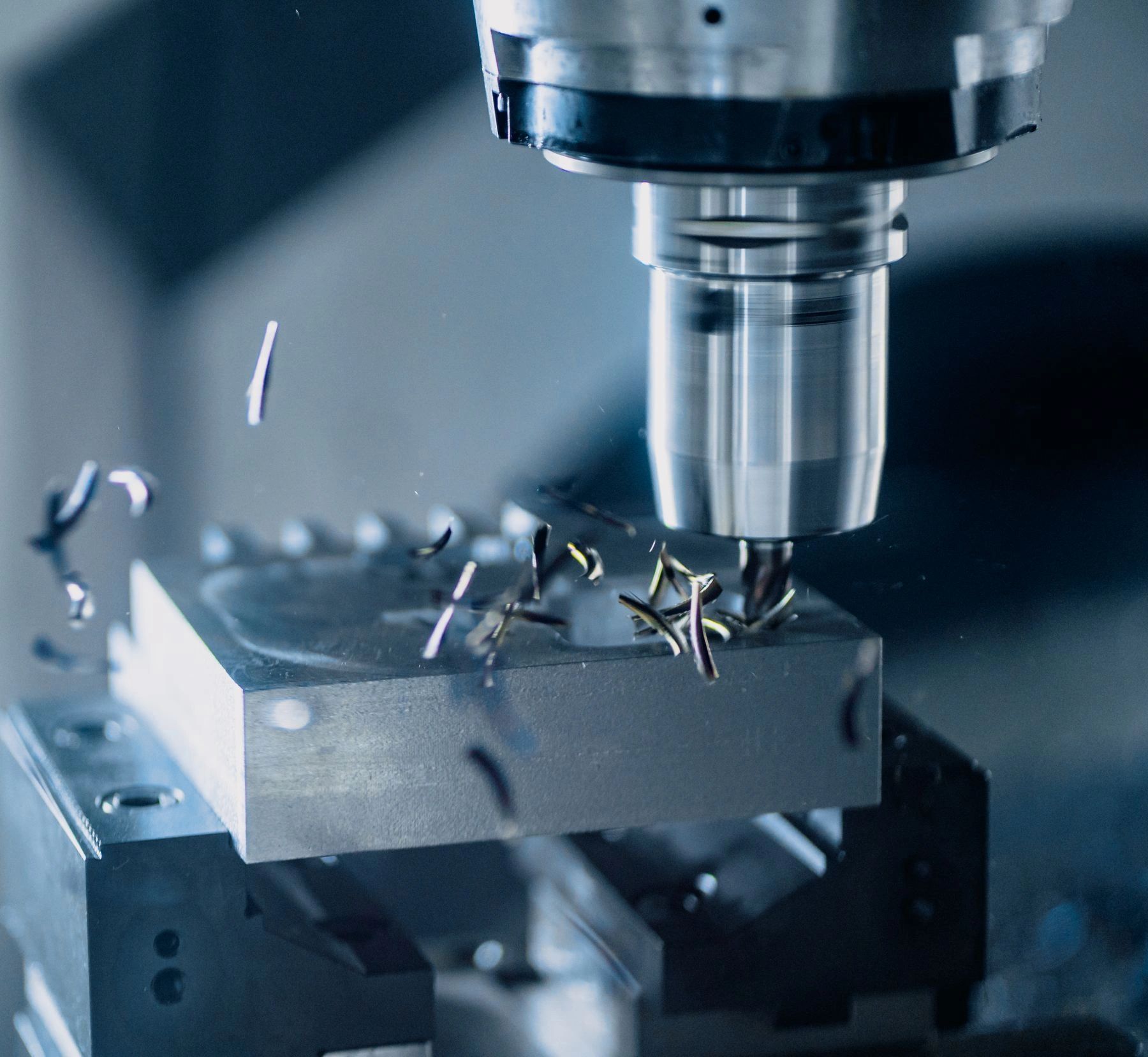 Representative stock photograph of a vertical CNC mill cutting metal.