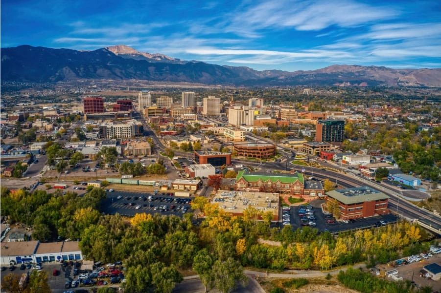 A vibrant cityscape with mountains in the background under a blue sky.