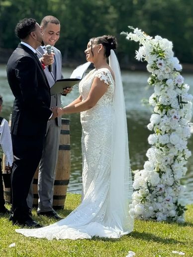 Couple exchanging vows at a lakeside wedding ceremony.