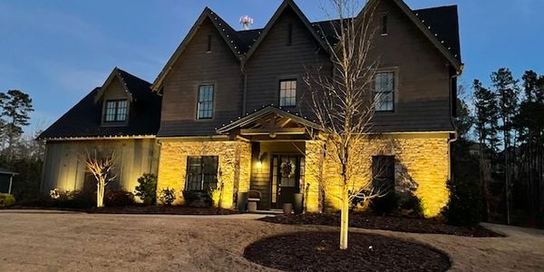 Proportioned lighting from driveway to the house with yard up-lighting to accent your investments.