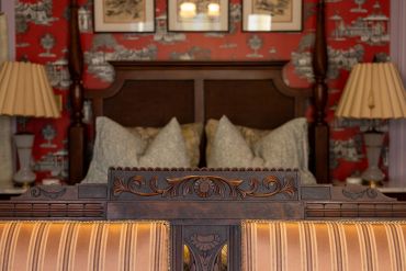 Ornate wooden headboard with vintage decor.