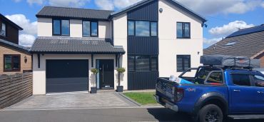 Modern two-story house with a blue pickup truck.