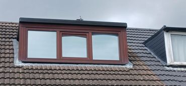 Three-paneled dormer window on a tiled roof.