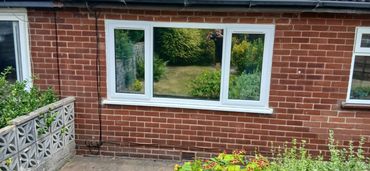 Garden view through a brick house window.