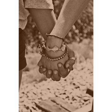 Holding hands in sepia tone, symbolizing trauma-informed relationship therapy