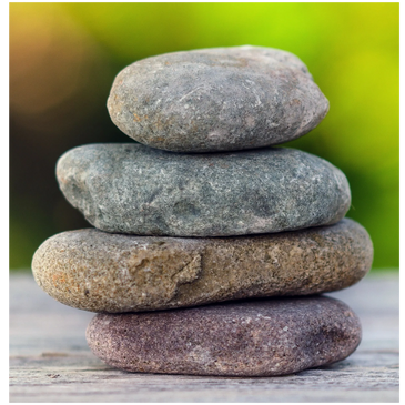 Serenity stone on wood deck, symbolizing grounding and healing in individual therapy