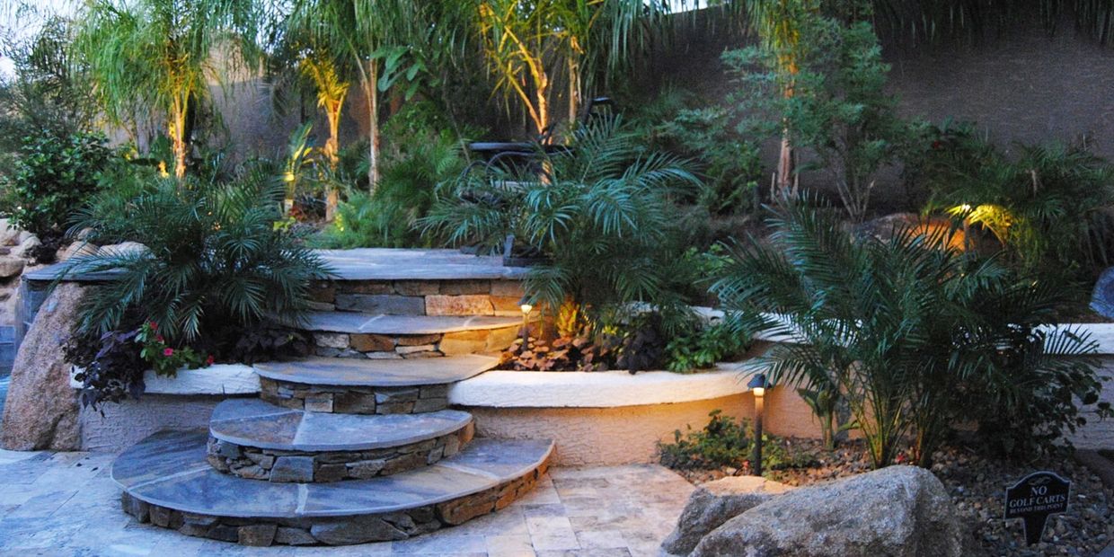 Arizona Backyard pool with travertine pavers and palm trees landscaping.