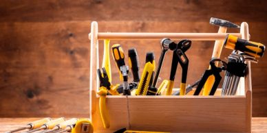 Wooden toolbox filled with various hand tools.