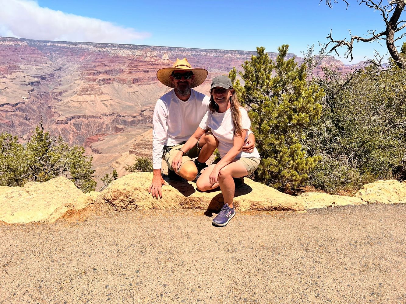 Couple posing at Grand Canyon overlook on a sunny day.