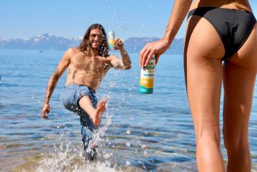 Man and woman enjoying drinks by the water.