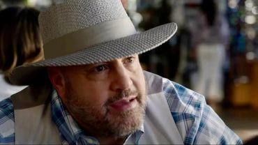 Man wearing a hat and plaid shirt.