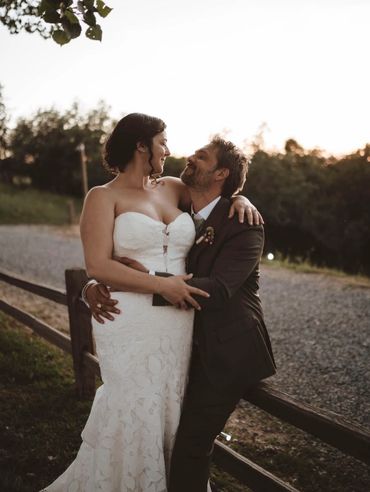 Bride and groom embracing outdoors at sunset on their wedding day.