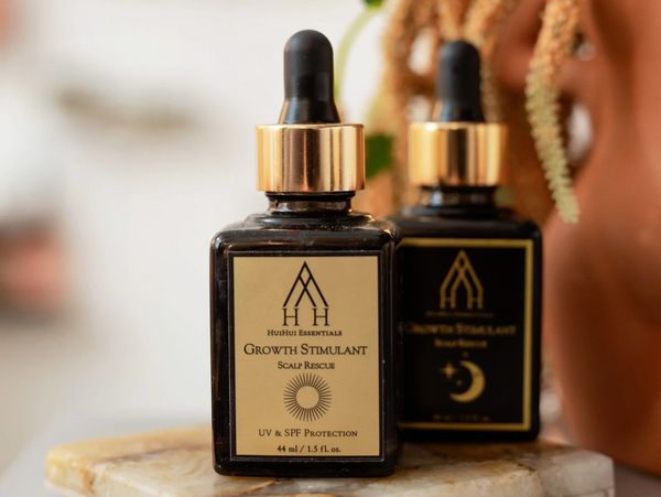 Two bottles of hair growth stimulant with dropper caps.