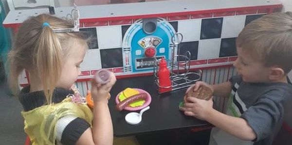 Two friends sharing a 'lunch' in our diner at Kidz Town. 
