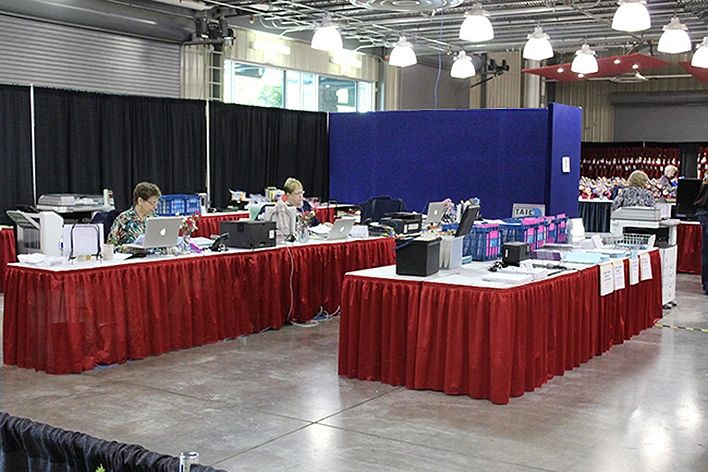 Black drape. blue fabric panels, tables with vinyl and red skirt