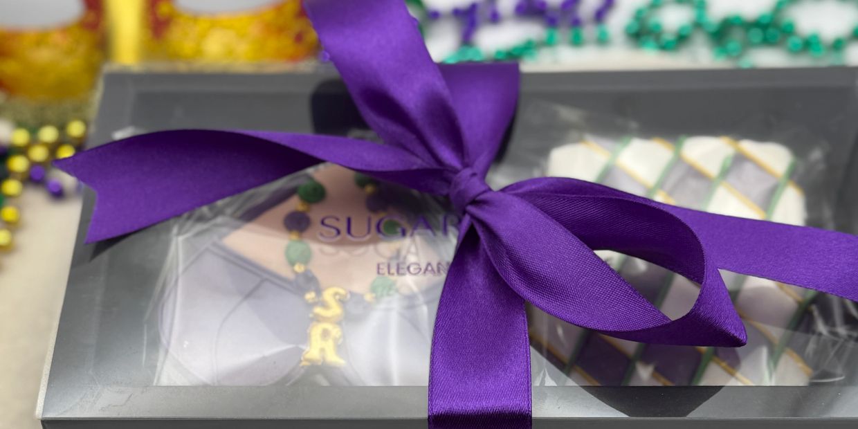 Gift box with purple ribbon and Mardi Gras beads.