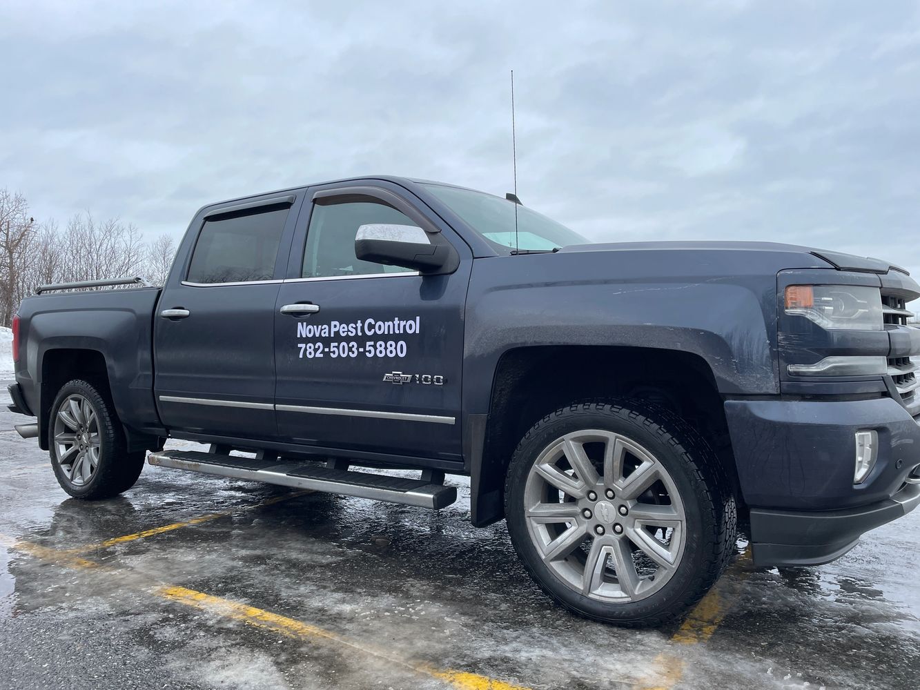 Black Chevrolet Silverado truck with Nova Pest Control signage on the door.