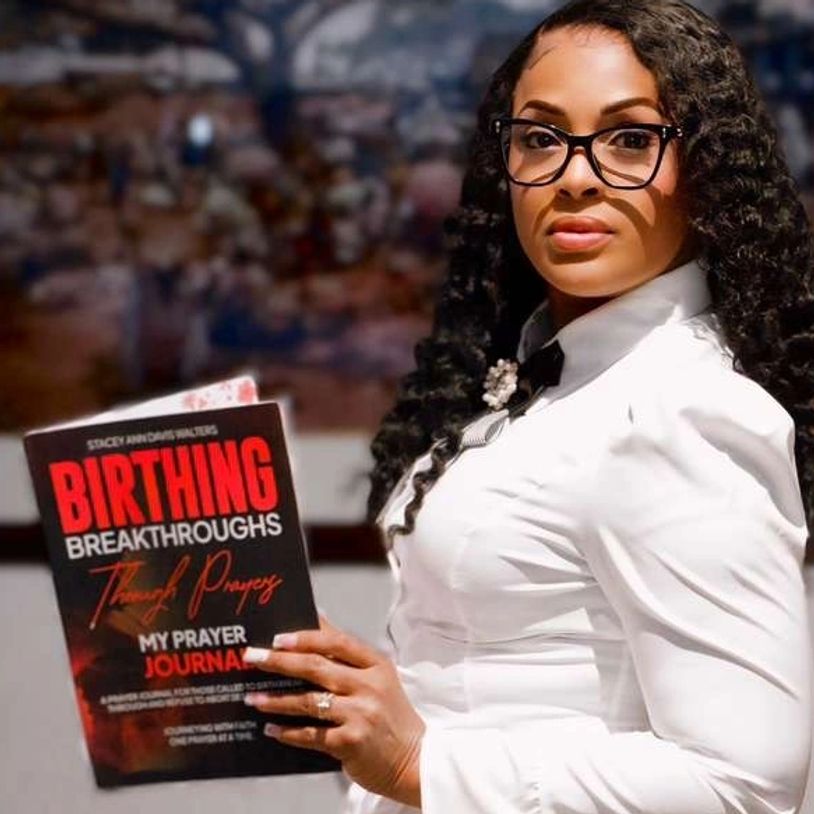Woman holding a prayer journal titled 'Birthing Breakthroughs Through Prayers'.