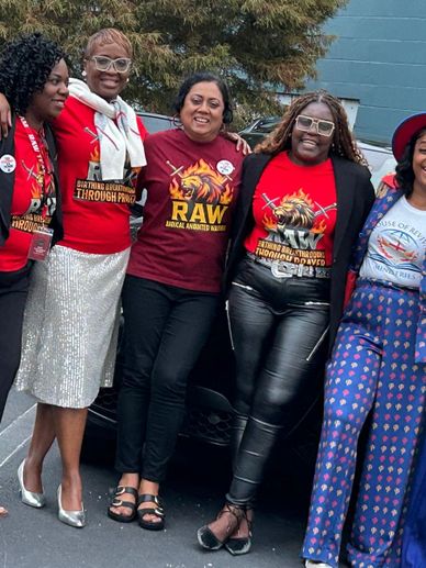A group of women wearing themed shirts posing together outdoors.