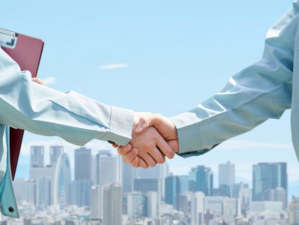 A handshake with city background.