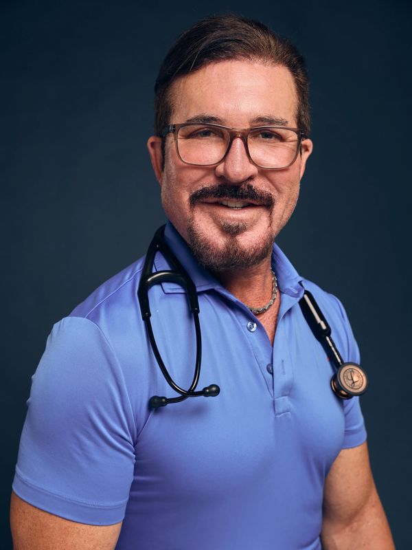 Smiling doctor wearing glasses and stethoscope.