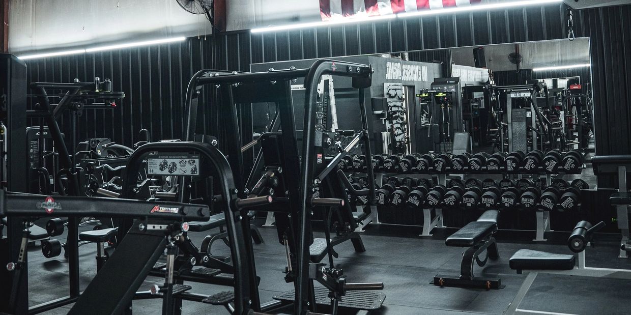 Empty gym with dumbbells and workout machines.