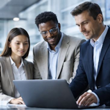 Three professionals collaborating over a laptop.