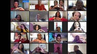 A joyful virtual meeting with participants making heart shapes with their hands.