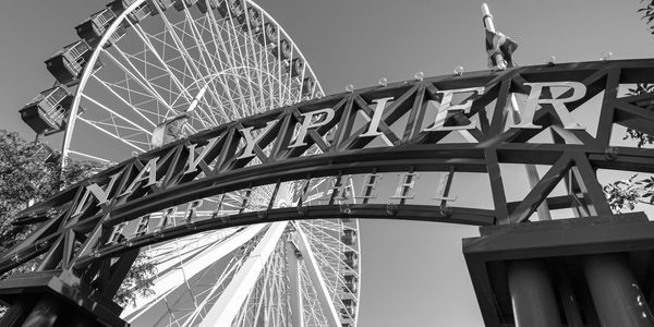 Black and white photo of Navy Pier Ferris wheel and entrance sign.